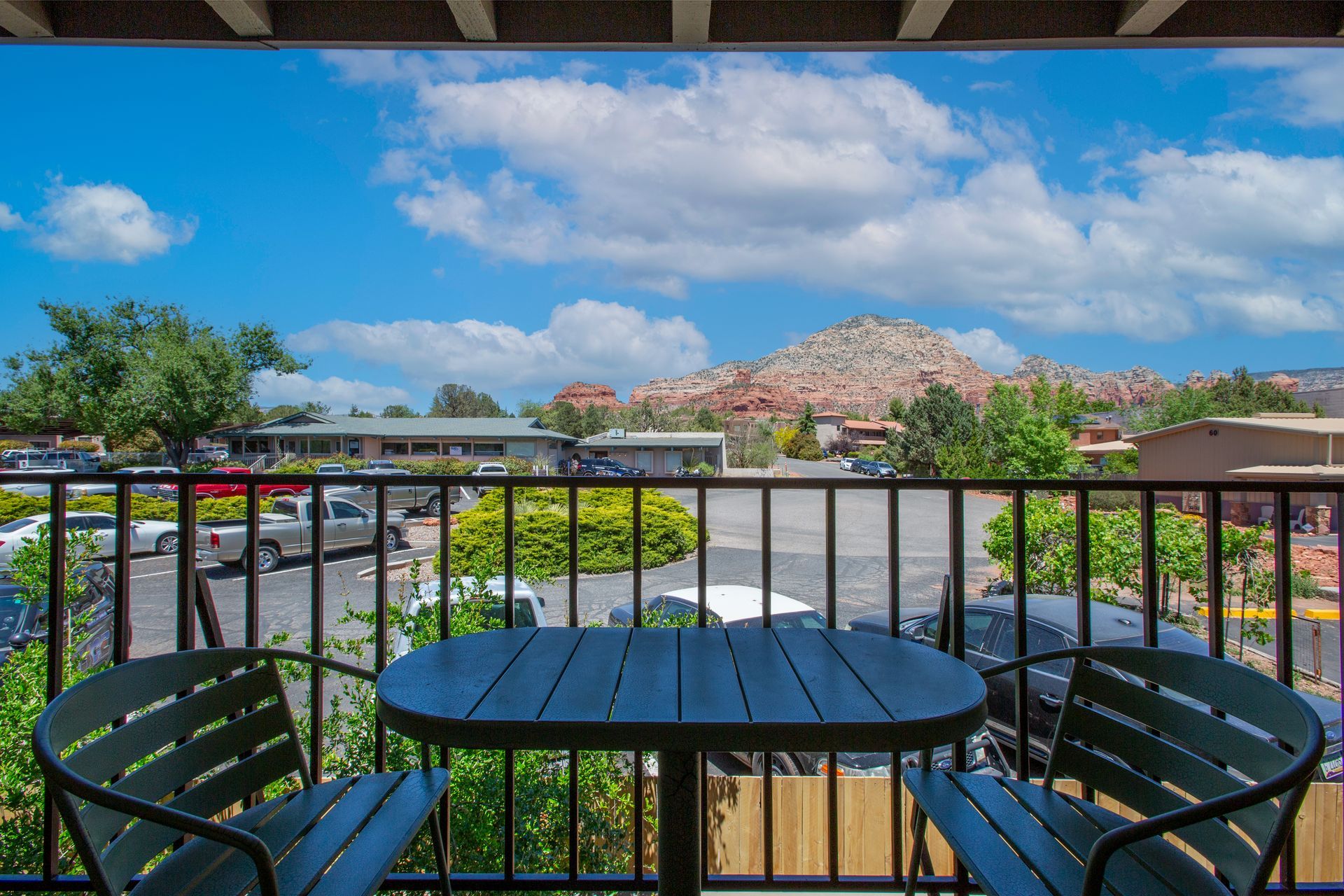 A balcony with a table and chairs and a view of a mountain.