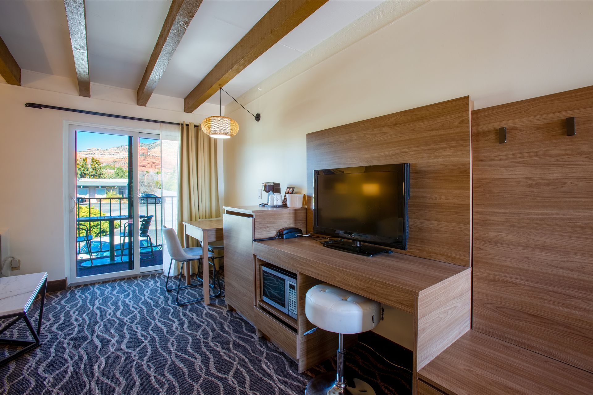 A hotel room with a flat screen tv and a balcony.