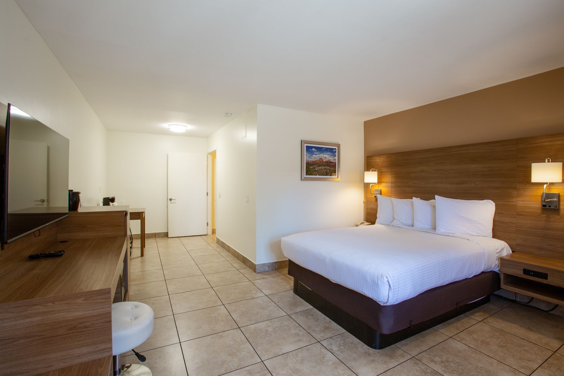 A hotel room with a king size bed and a flat screen tv