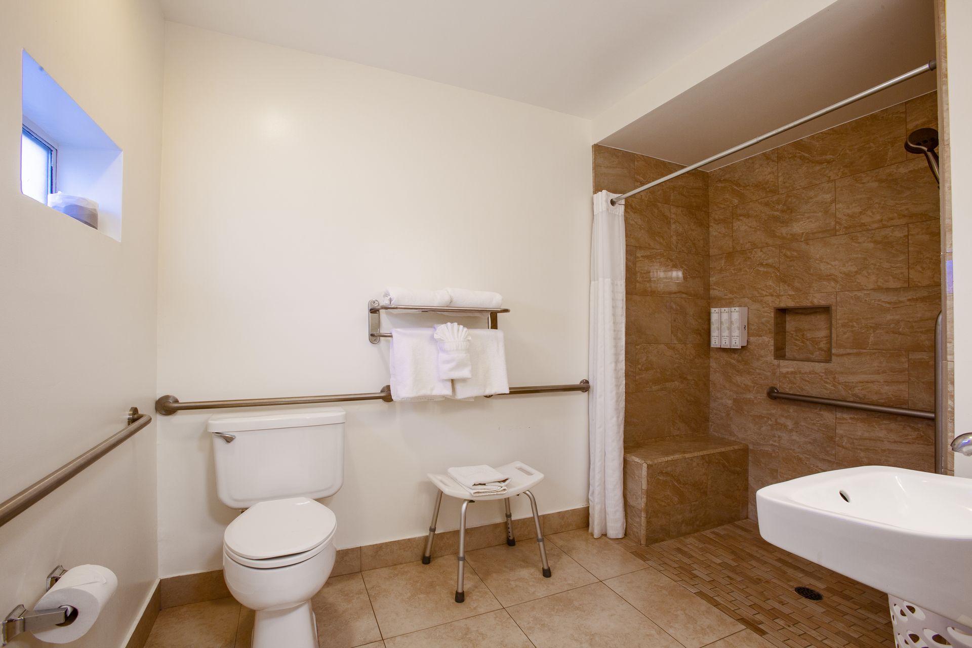 A bathroom with a toilet , sink and shower.