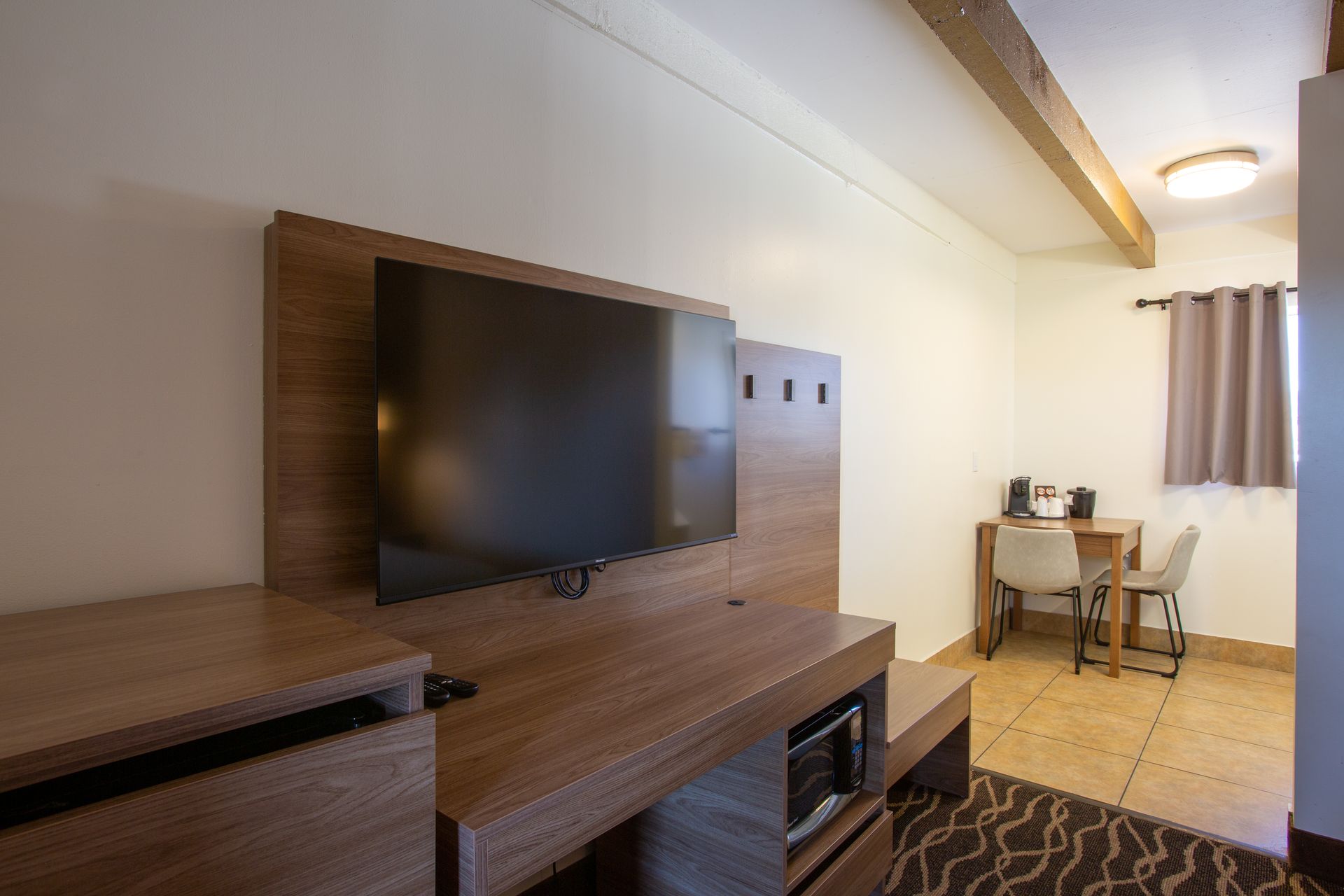 A hotel room with a flat screen tv mounted on the wall.