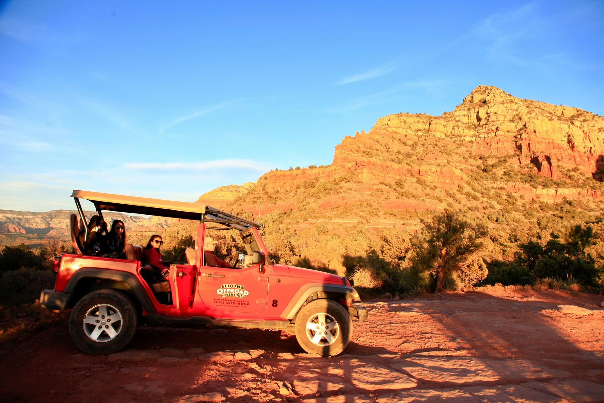 Red Jeep parked on a dirt road with Sedona mountains in the background near Dreamcatcher Inn