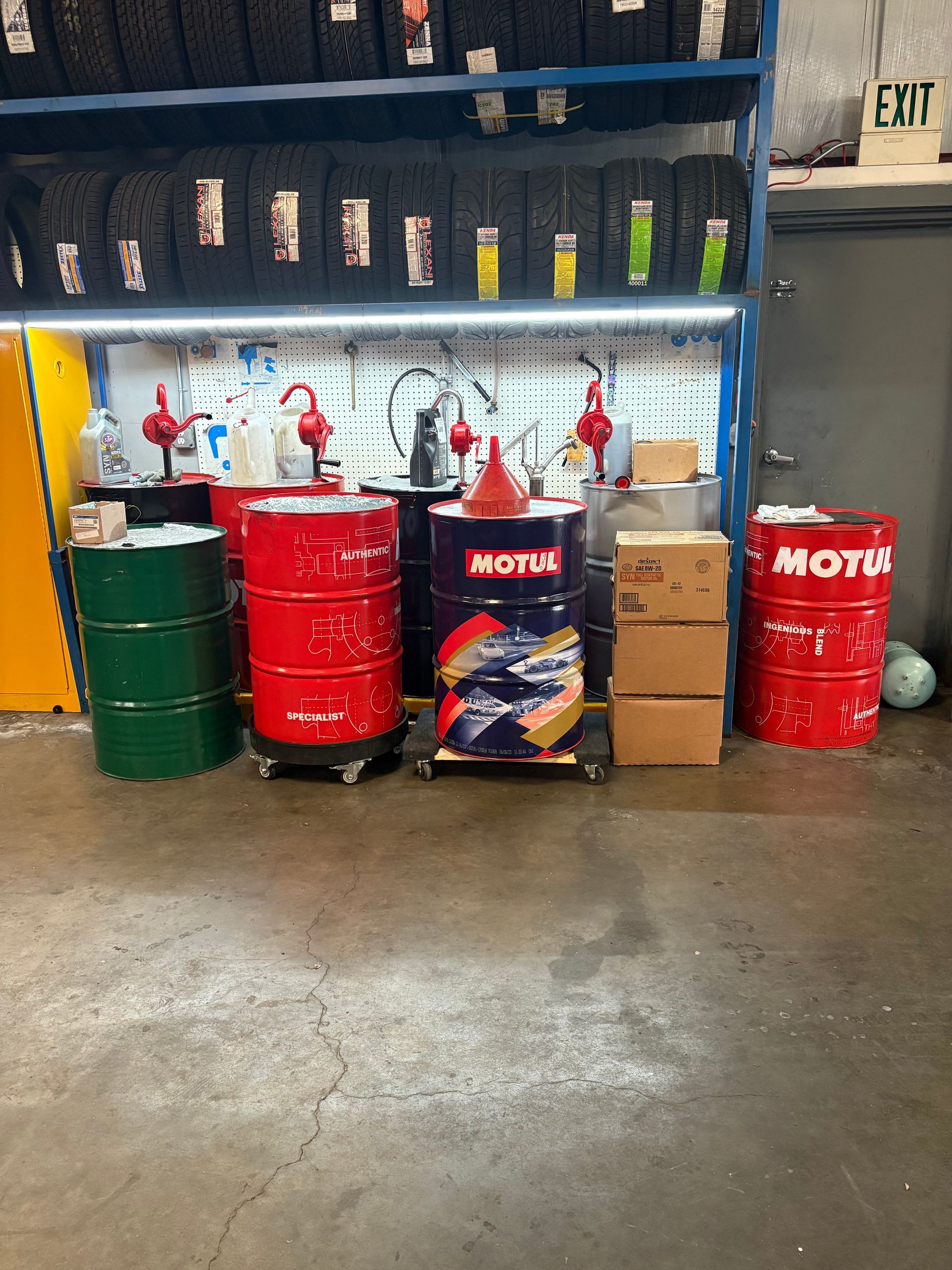 A bunch of oil barrels are sitting on the floor in a garage. | Platinum Motors Martinez