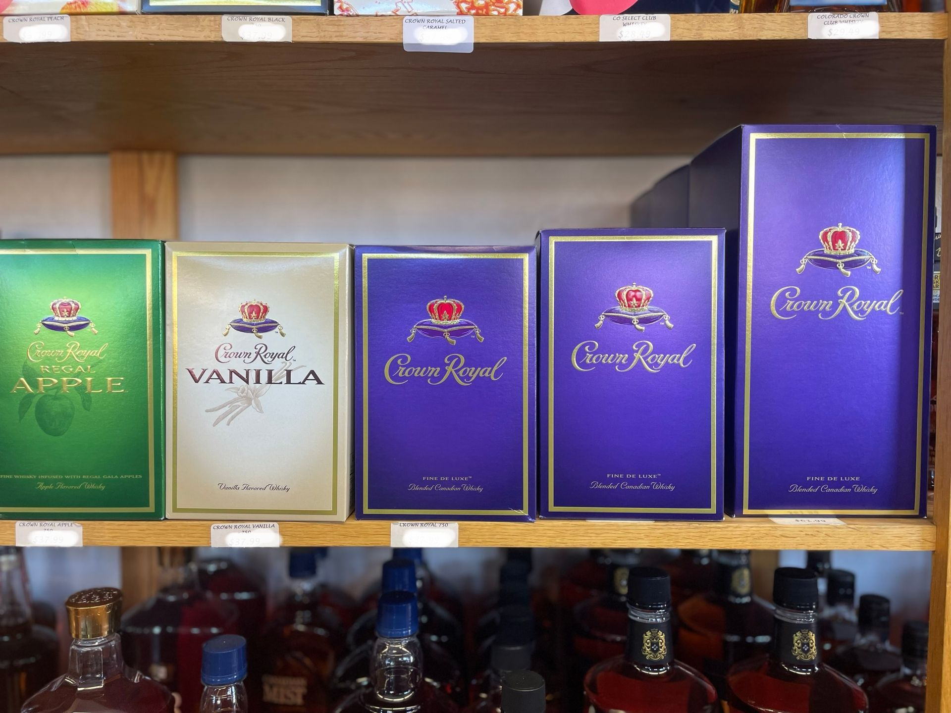 Several boxes of crown royal are on a shelf
