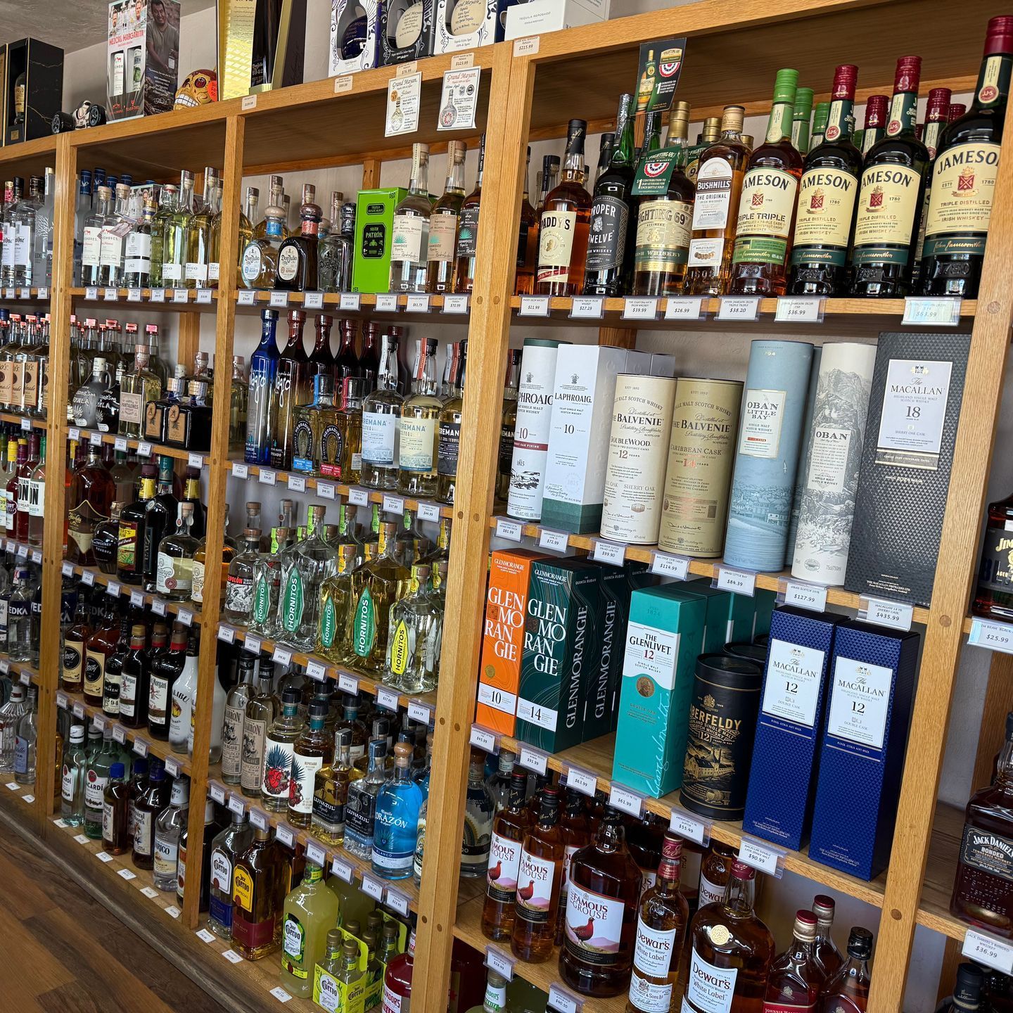 A row of shelves filled with lots of bottles of liquor.