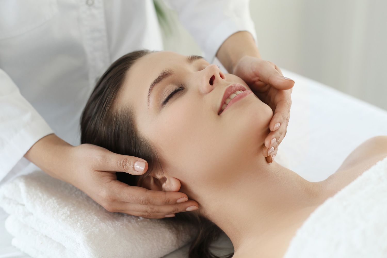 A woman is getting a head massage at a spa.