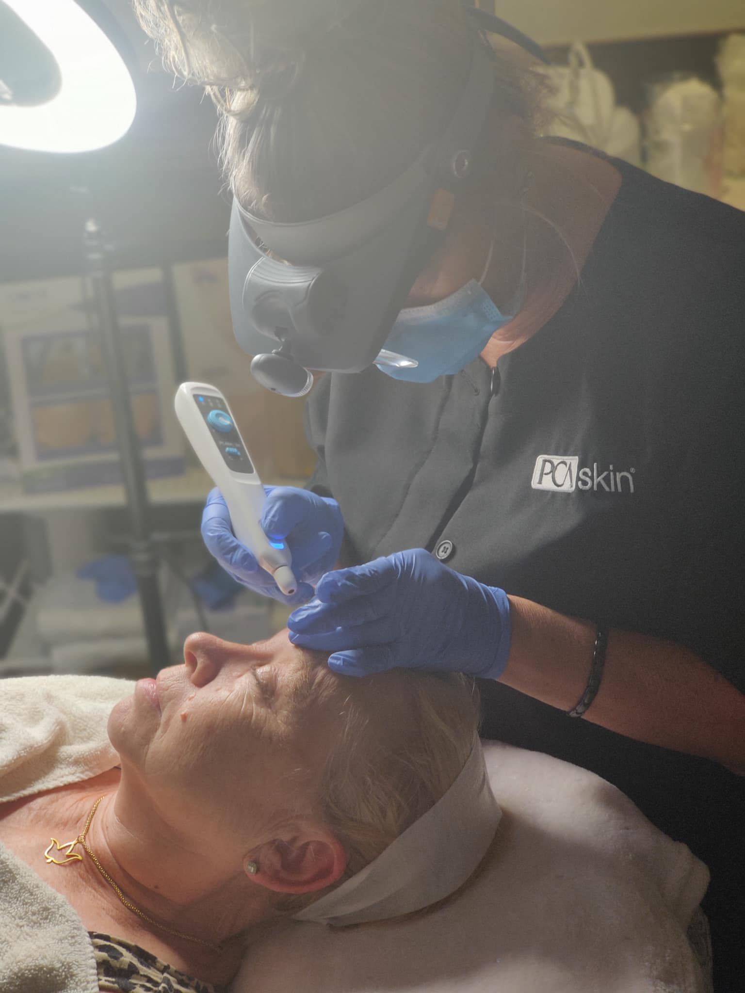 a woman is giving an older woman a facial treatment .