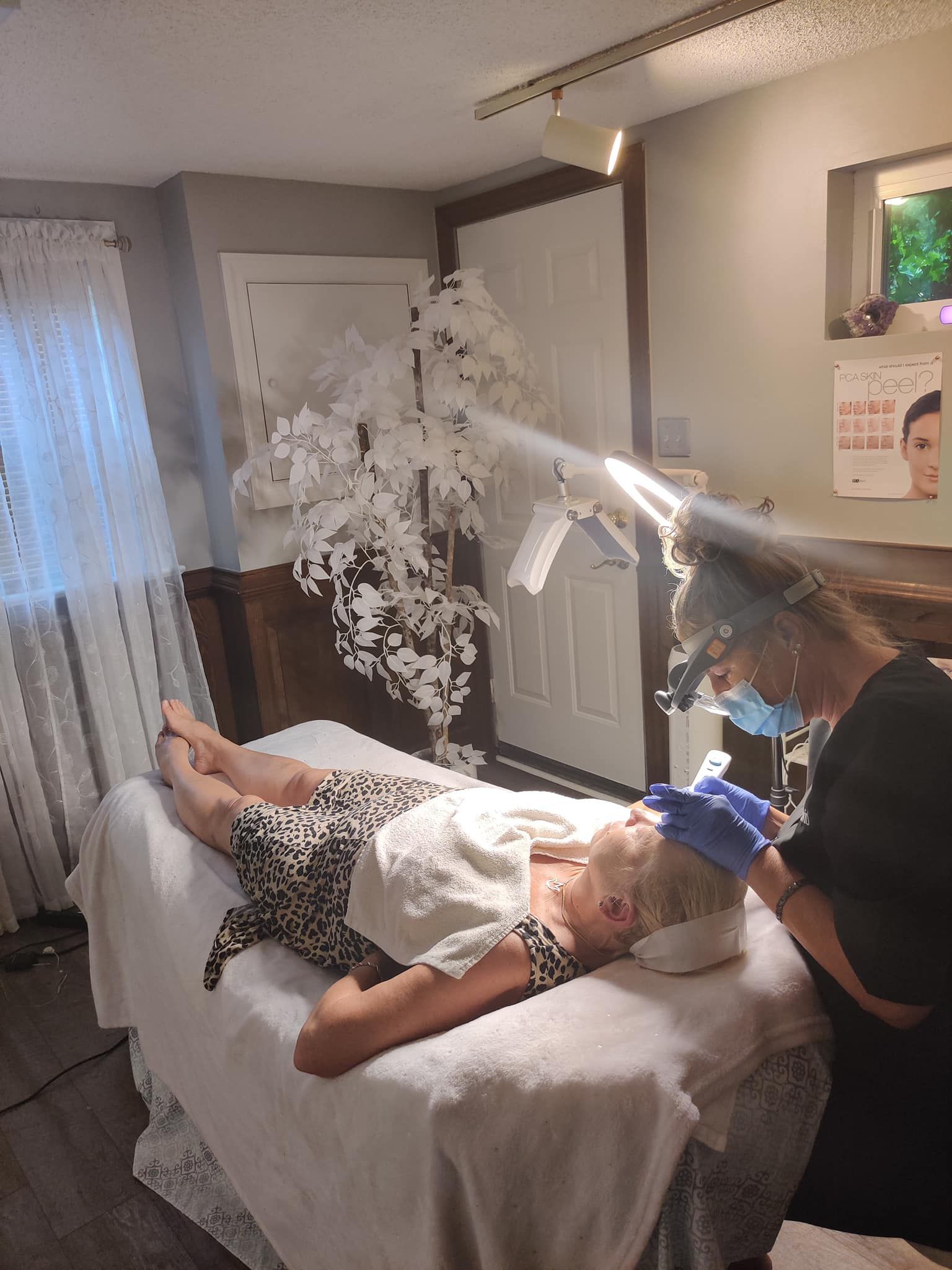 A woman is laying on a bed getting a facial treatment.