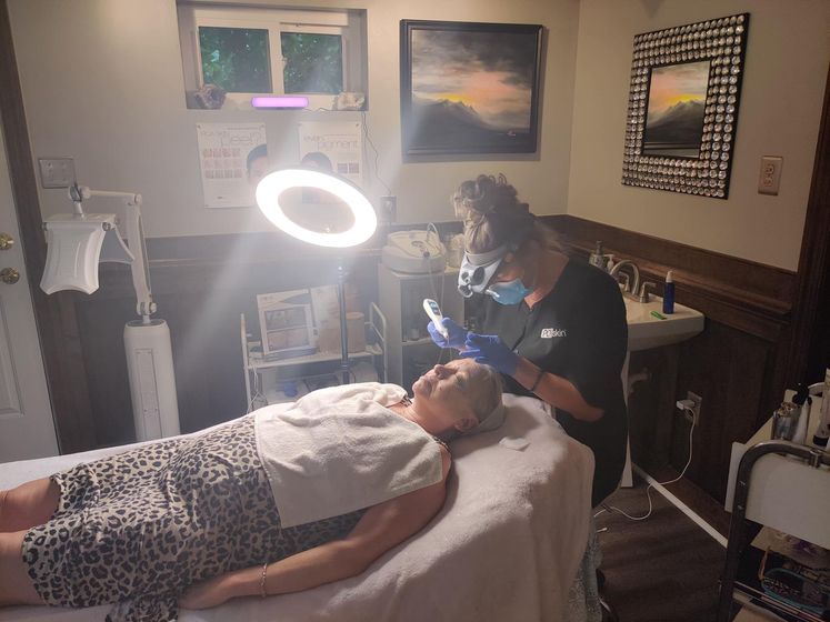 A woman is laying on a bed getting a facial treatment.