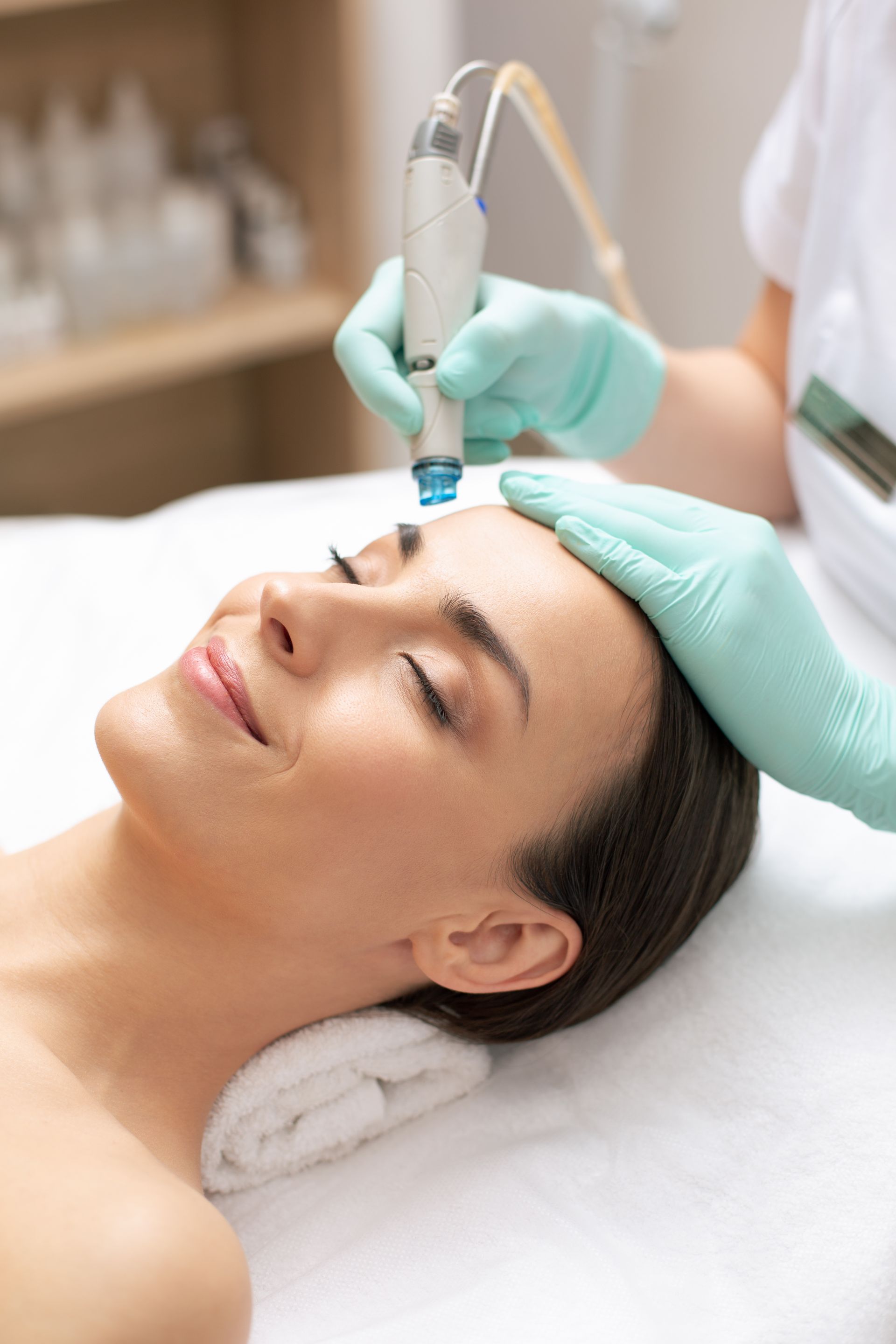 A woman is getting a facial treatment at a beauty salon.