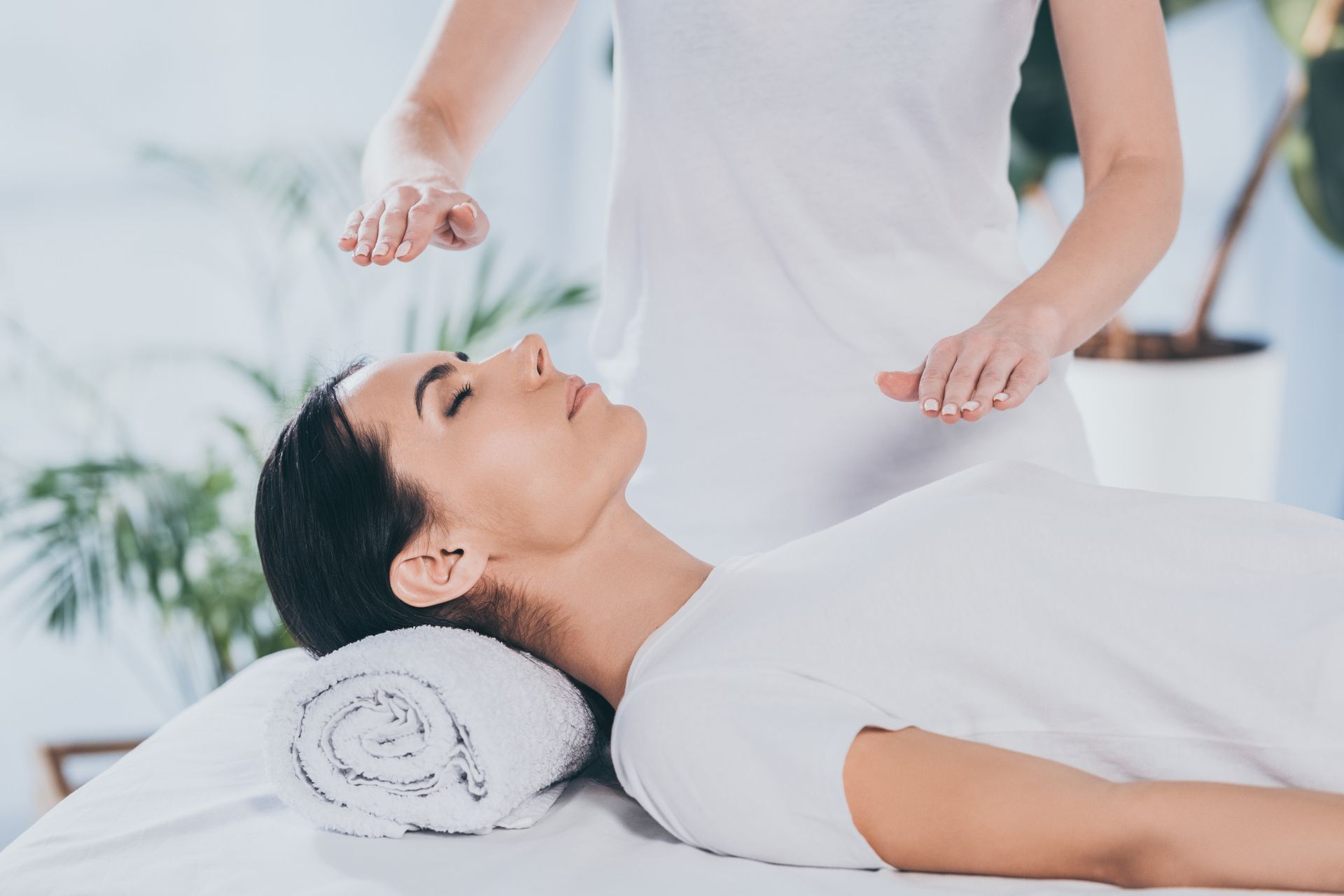 A woman is getting a reiki treatment at a spa.