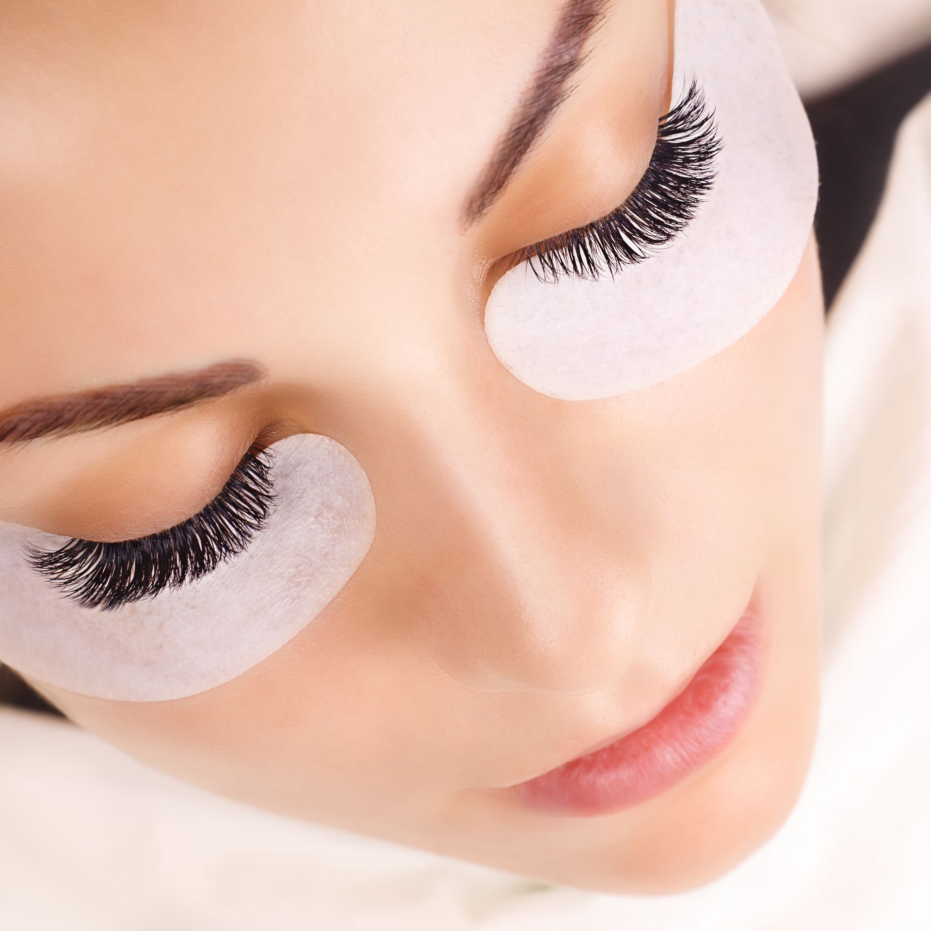 A close up of a woman 's face with false eyelashes on her eyes.