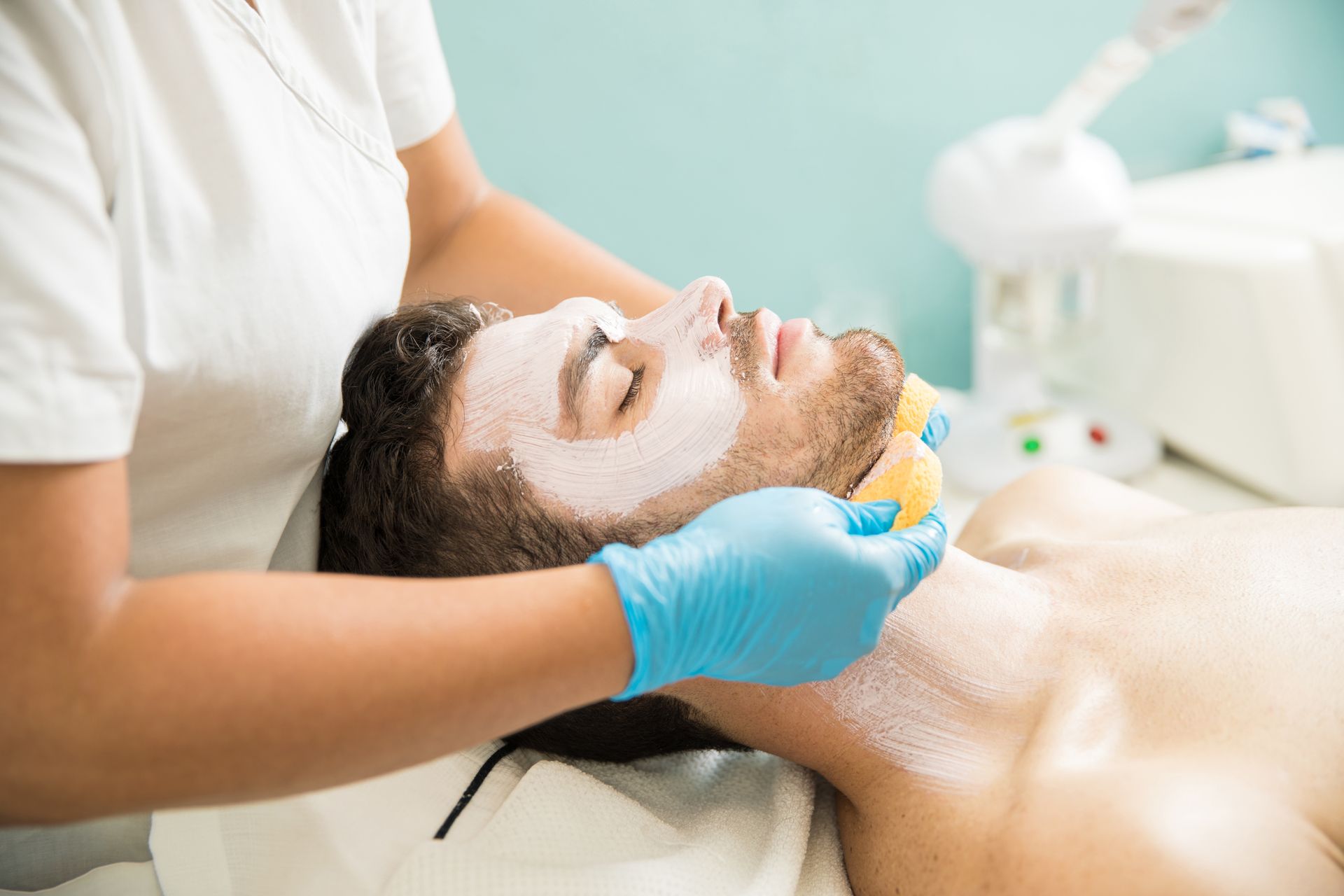 A man is getting a facial treatment at a spa.