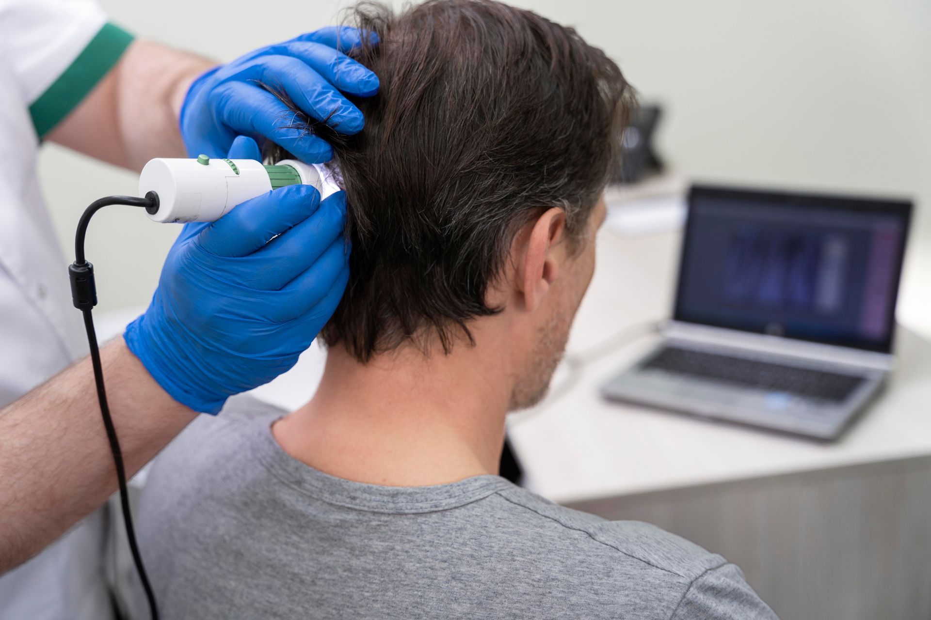 A man is getting his hair examined by a doctor.