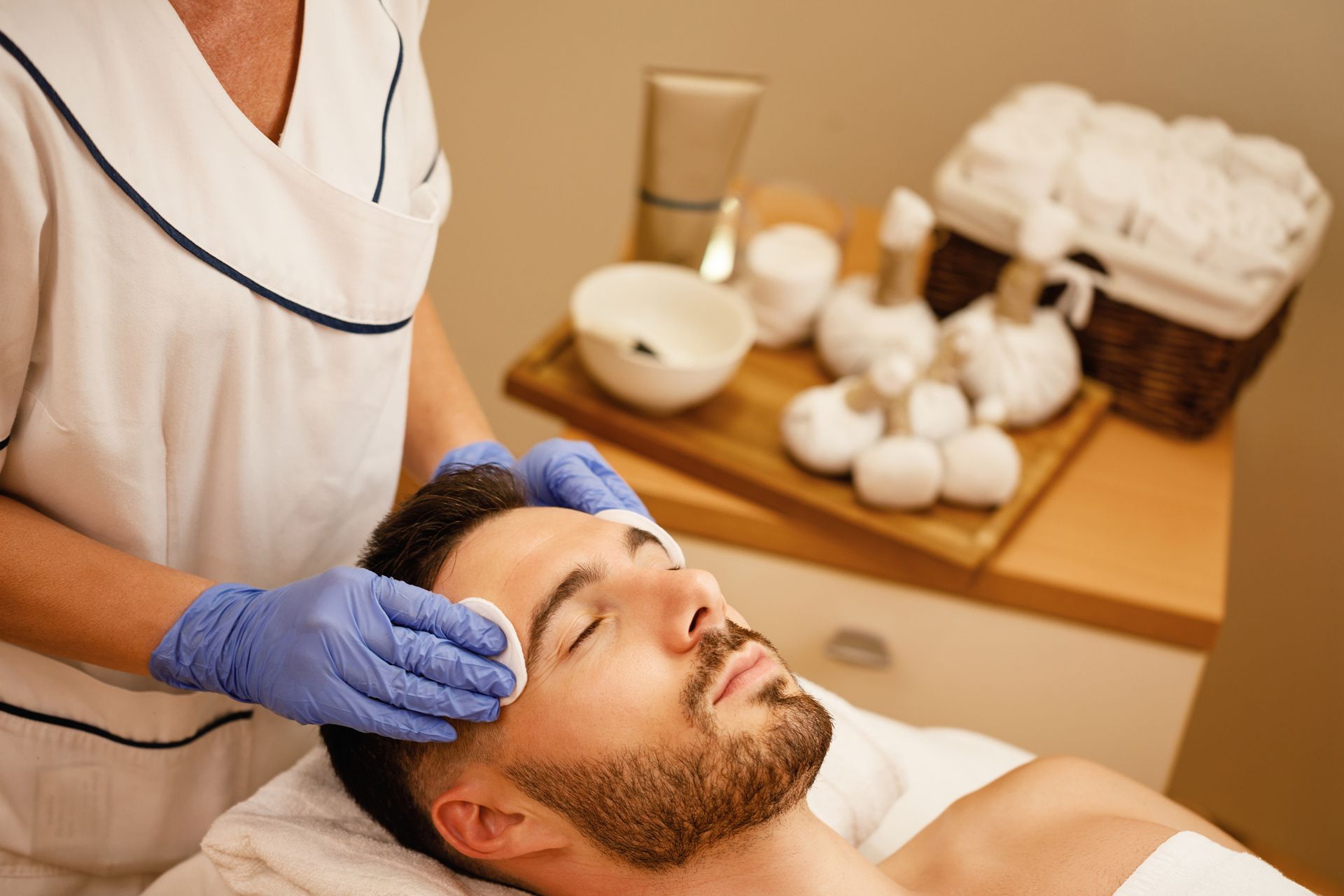 A man is getting a facial treatment at a spa.