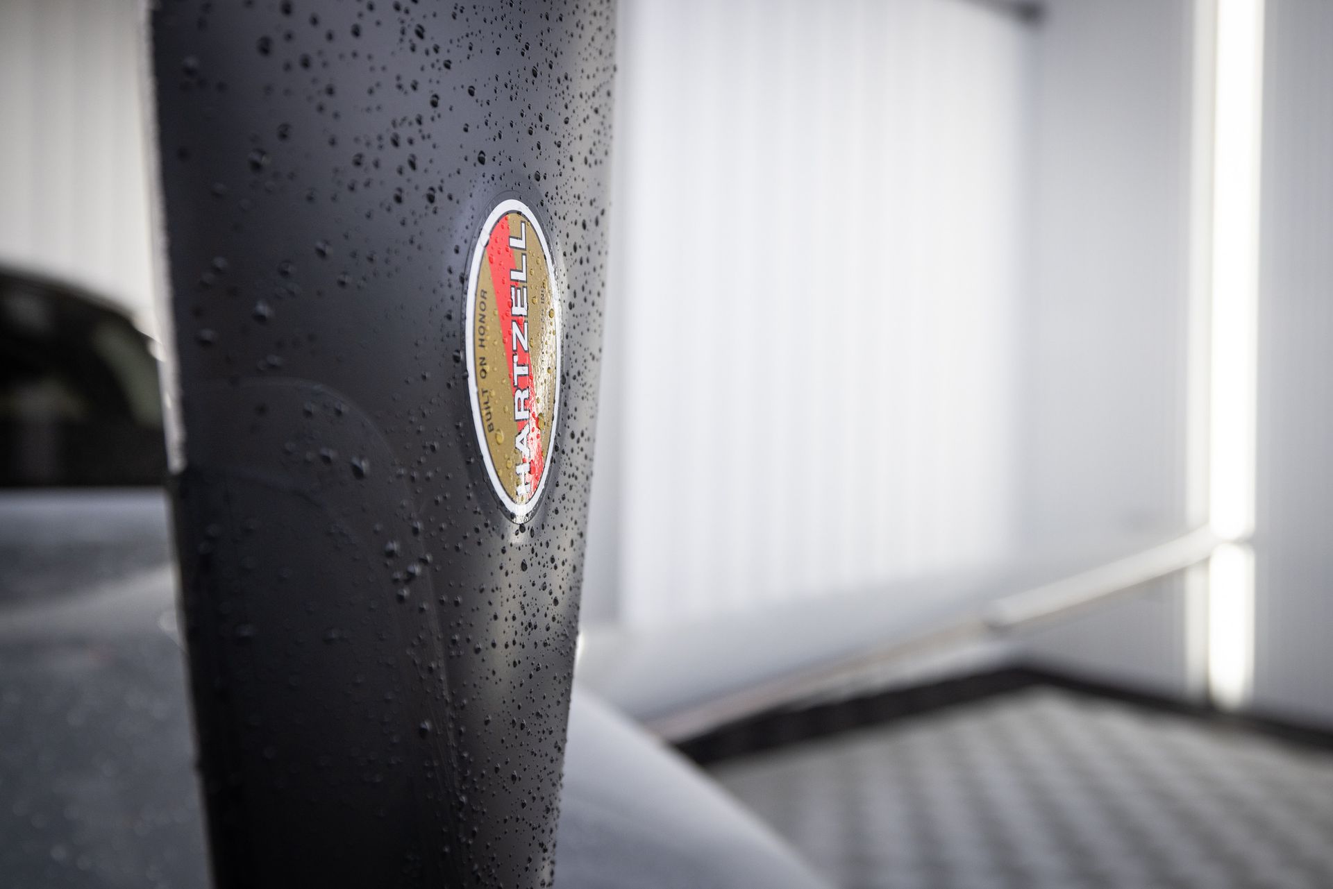 A close up of a black cup with water drops on it.