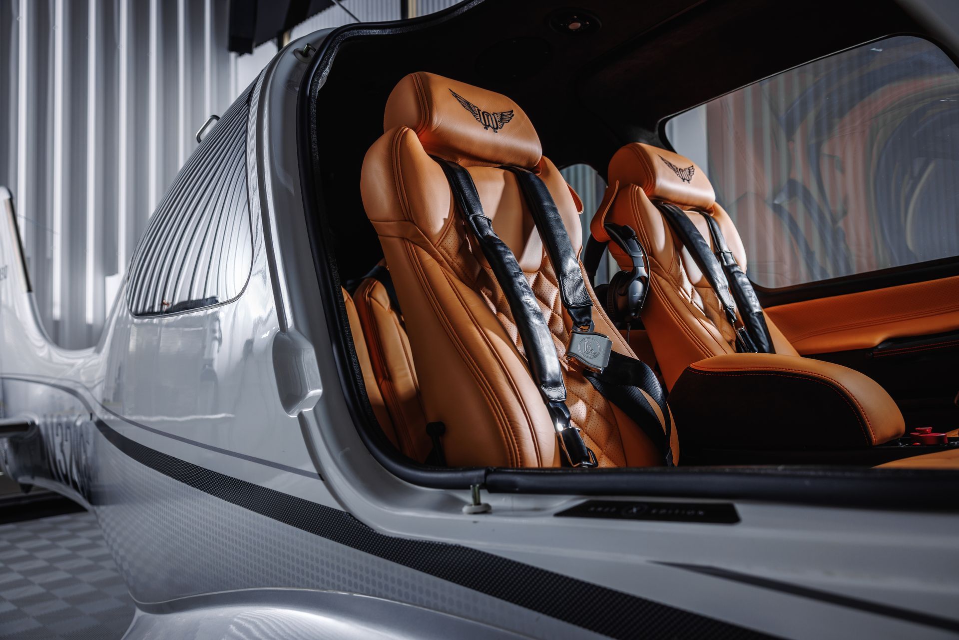 The inside of a small airplane with brown leather seats.