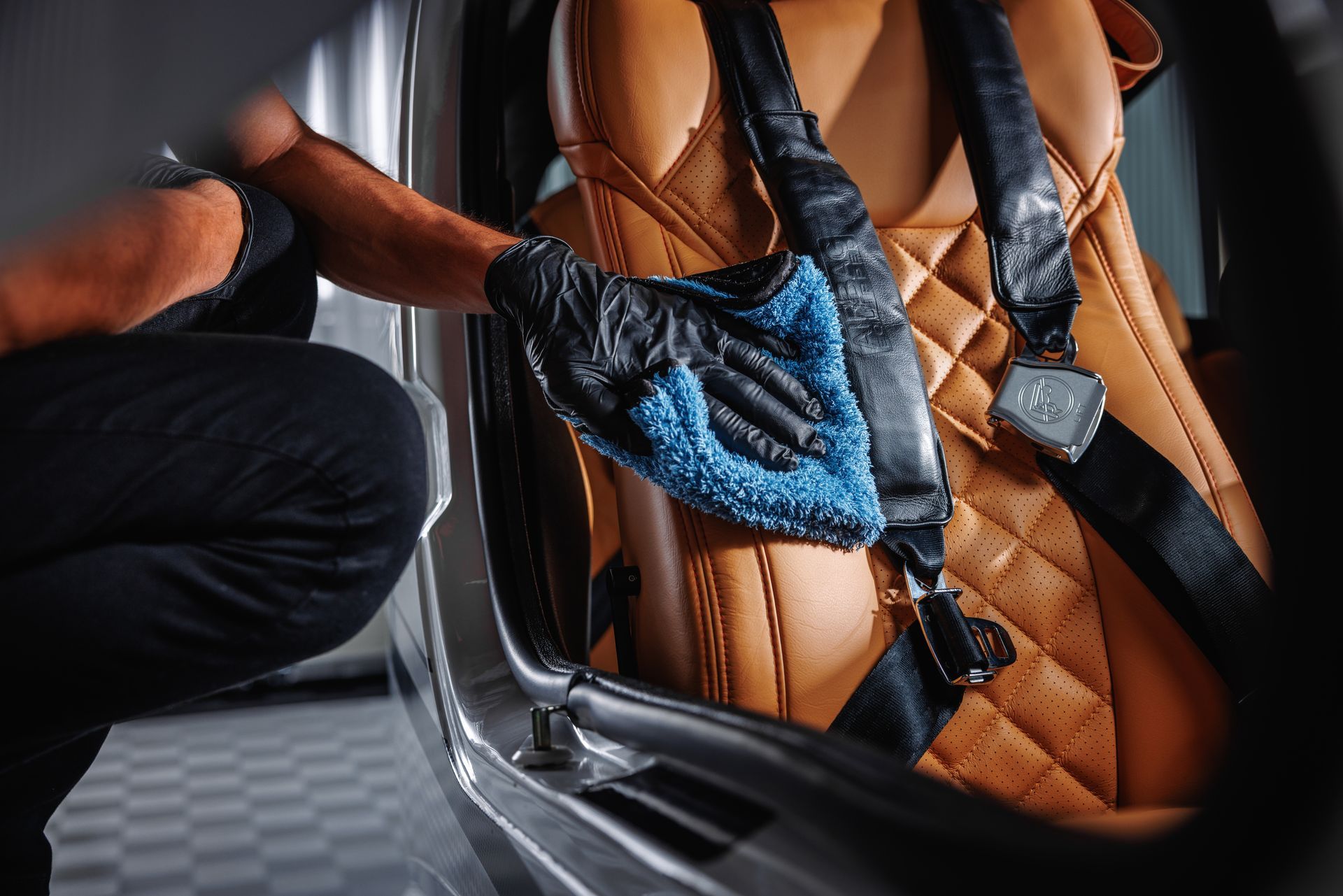 A person is cleaning the seats of a car with a cloth.