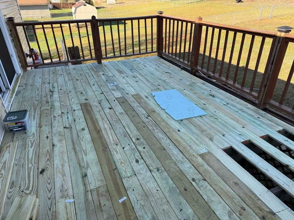 Wooden deck being rebuilt with missing planks. Sunlight.