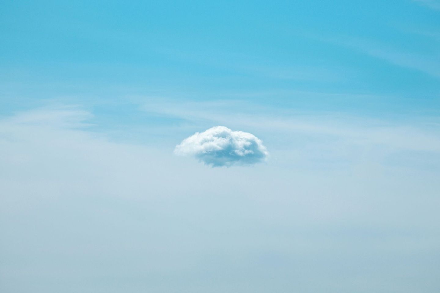 Small white cloud floating in a clear blue sky
