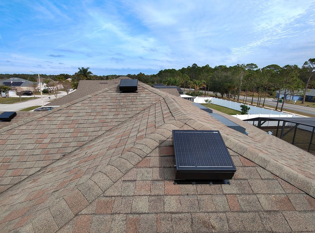 The roof of a house with a solar panel on it.