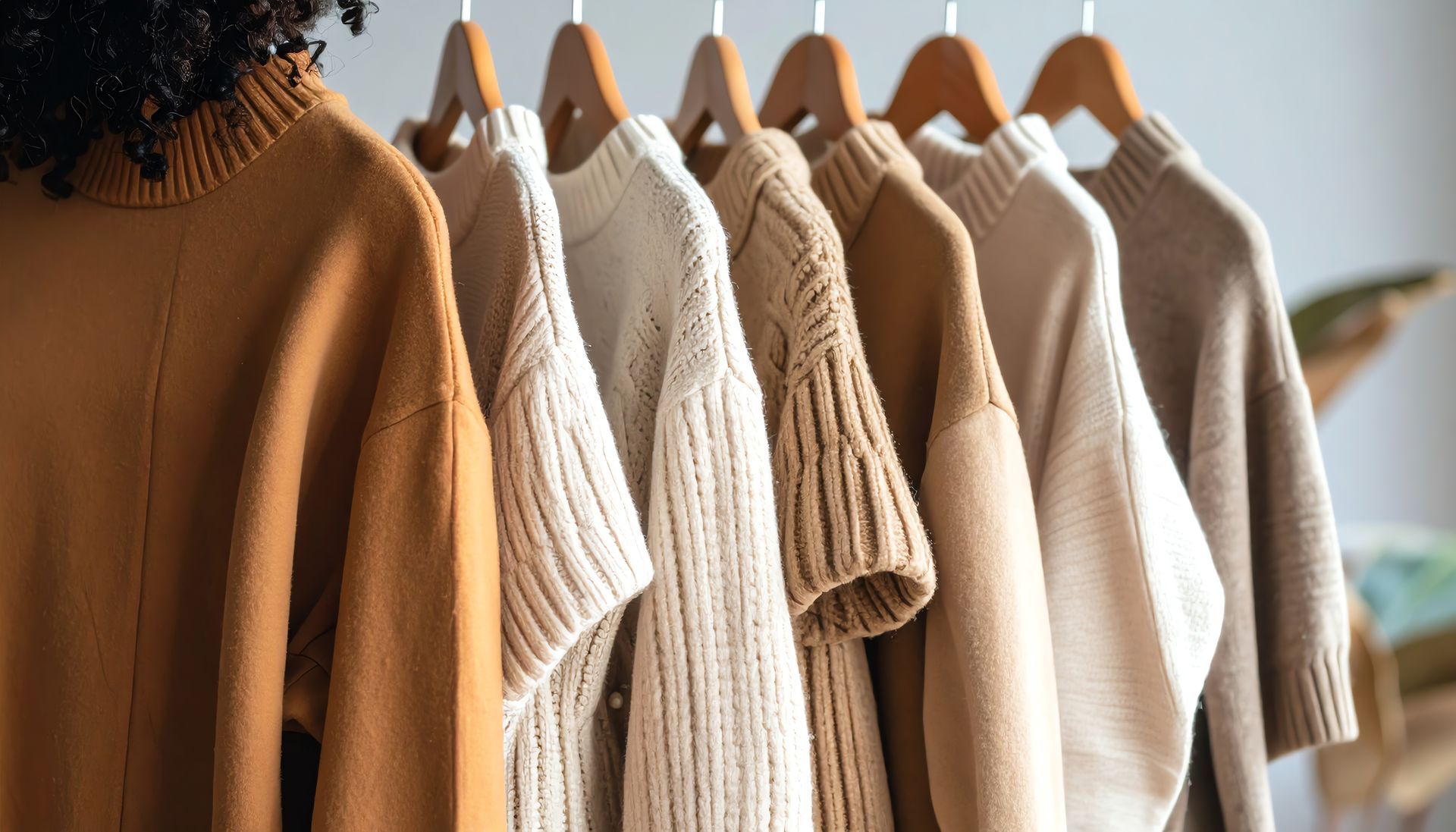 Sweaters colgados tonos tierra.