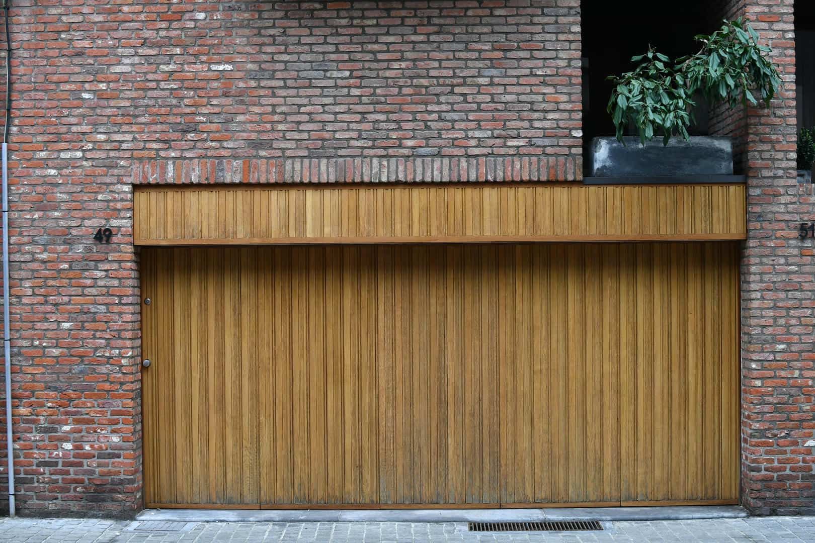 A brick building with a wooden garage door.