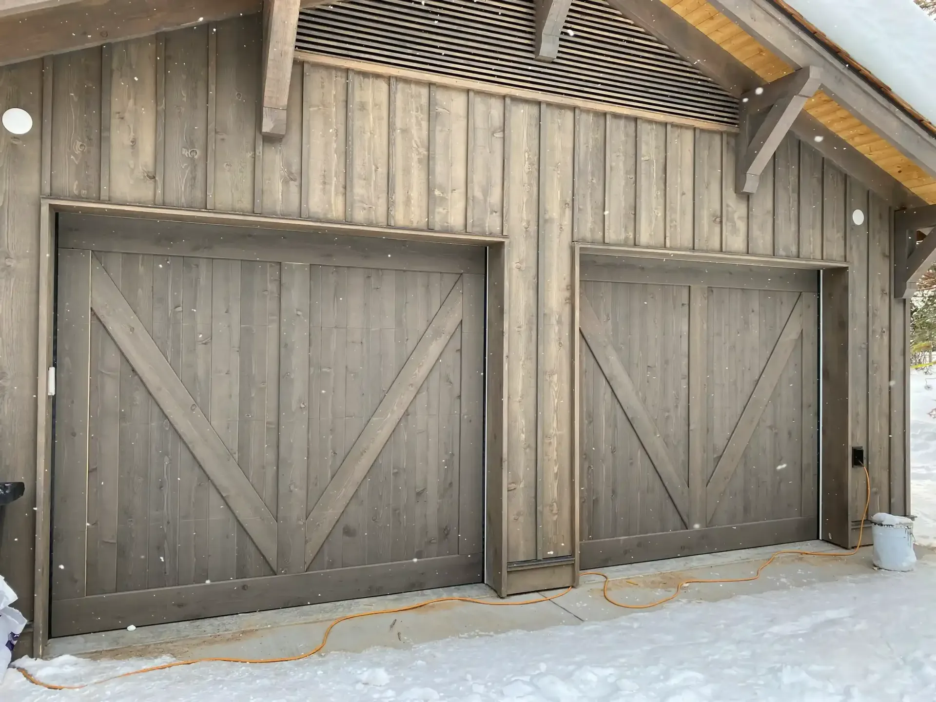 The garage doors are made of wood and are very large.