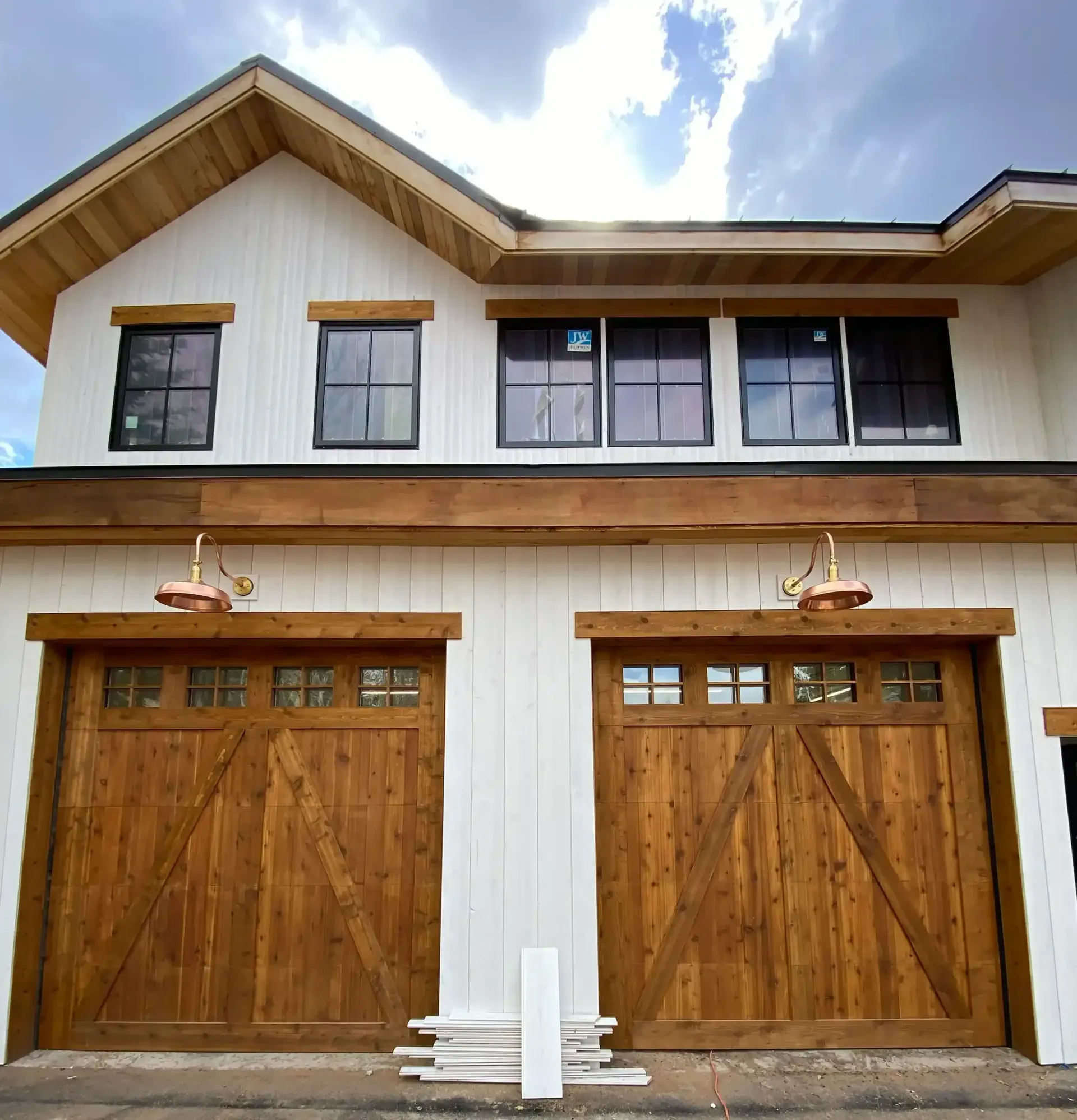 A white house with wooden garage doors and windows