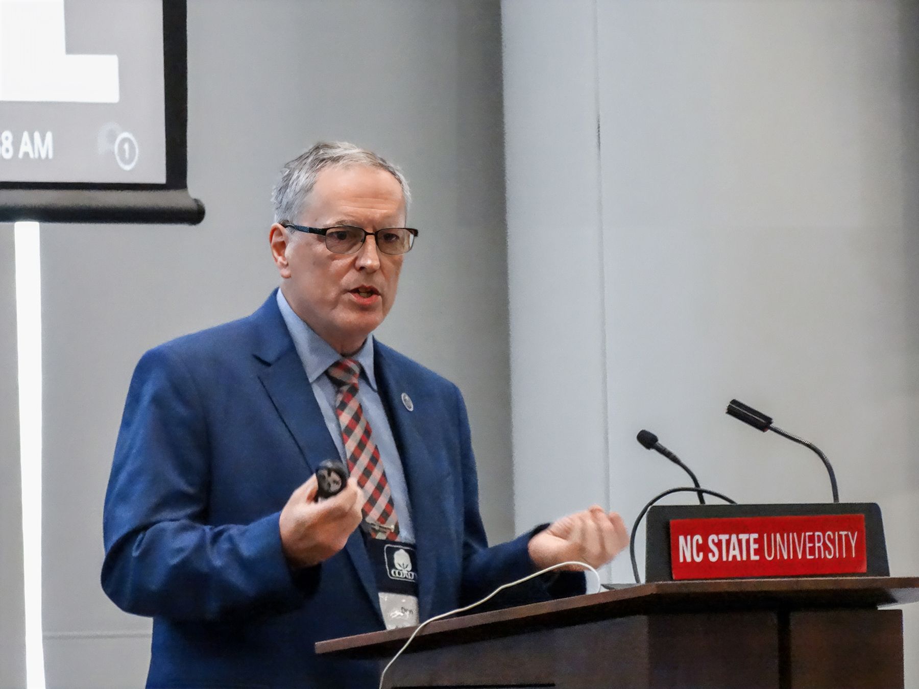 Man in a blue suit speaking at a podium with 