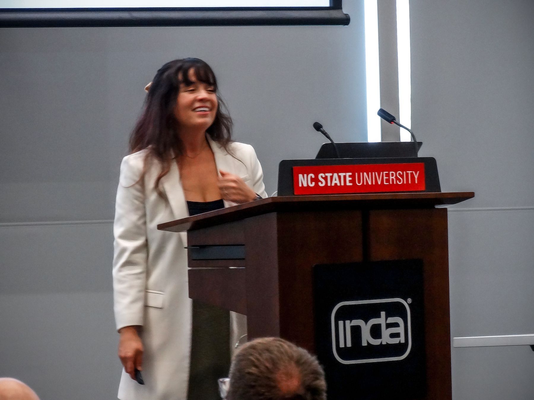 Woman presenting at a podium that says 