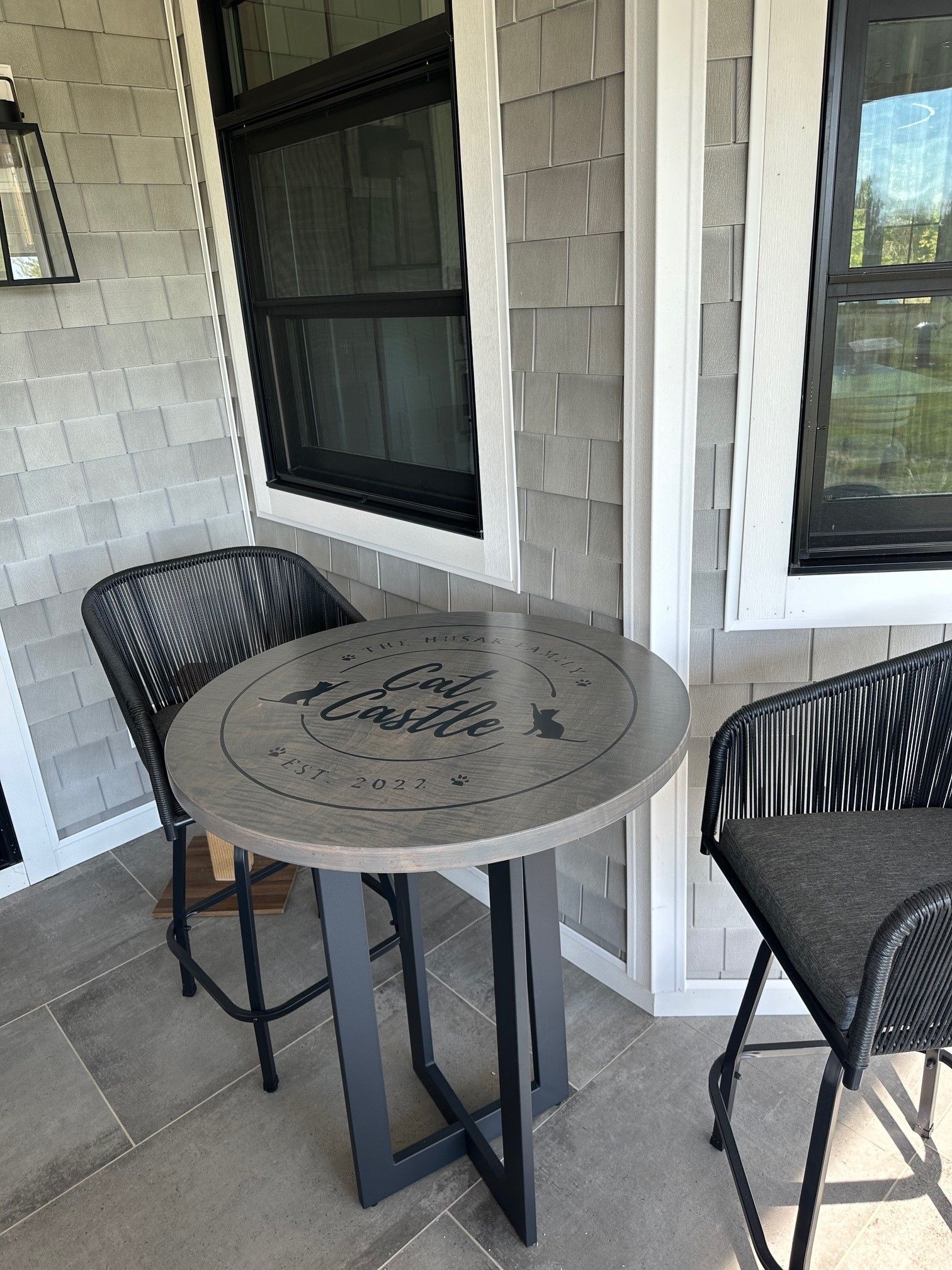 There is a table and chairs on the porch of a house.