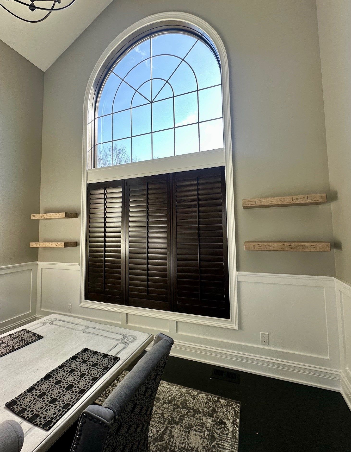 A living room with a large window and shutters