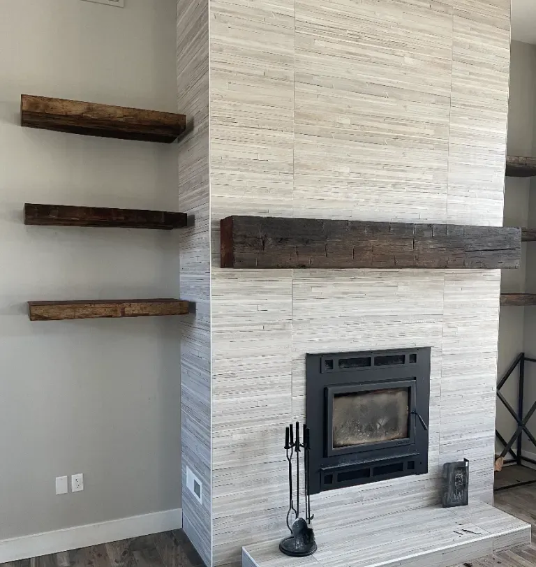A living room with a fireplace and wooden shelves.