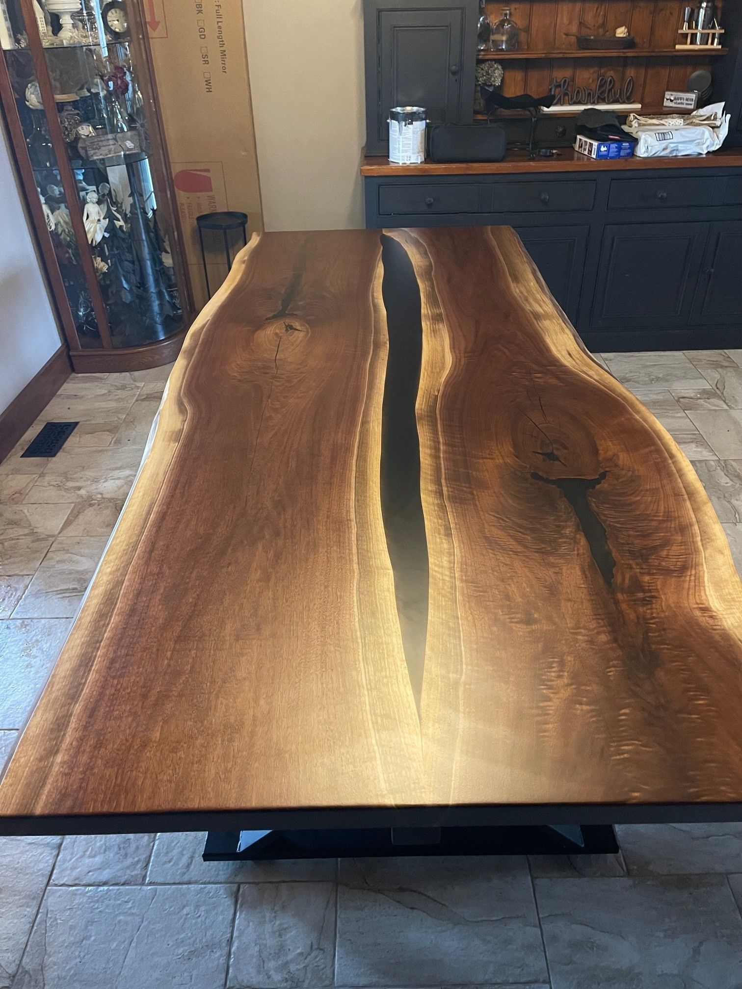 A large wooden table is sitting on a tiled floor in a room.