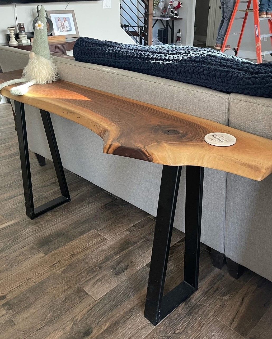 A wooden table is sitting next to a couch in a living room.