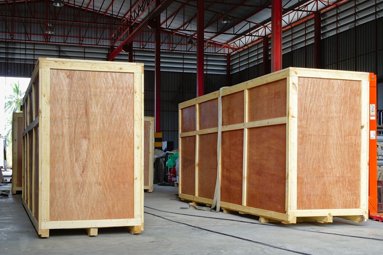 Wooden crates on pallets inside a warehouse, likely for shipping.