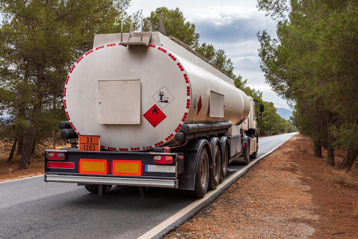 Tanker truck on a road, transporting a hazardous material.