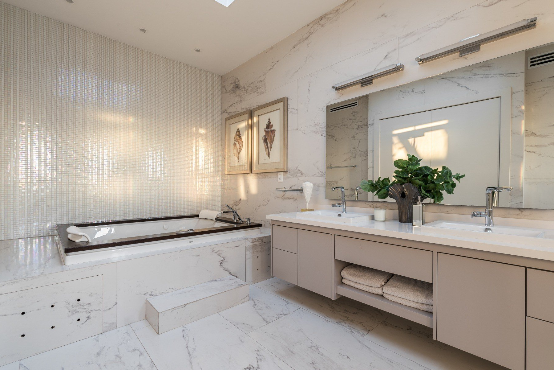 A bathroom with two sinks, a tub and a large mirror.