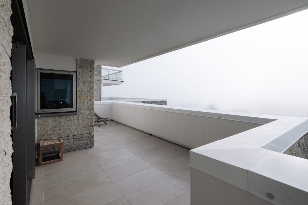 A balcony with a window on the wall.