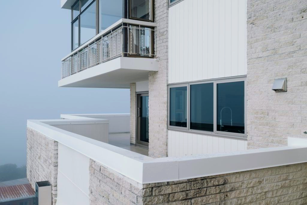 A large white building with a balcony and a lot of windows.