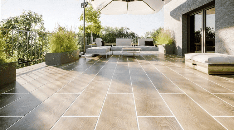 A patio with a wooden floor and a white umbrella.