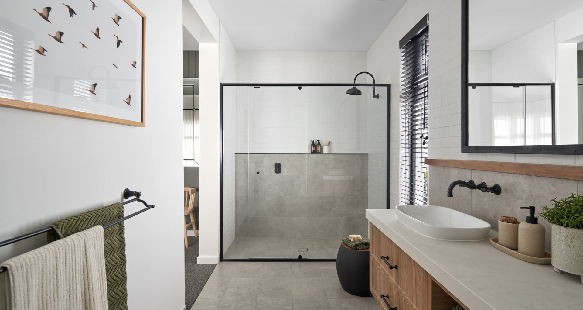 A bathroom with a sink, mirror and walk in shower.