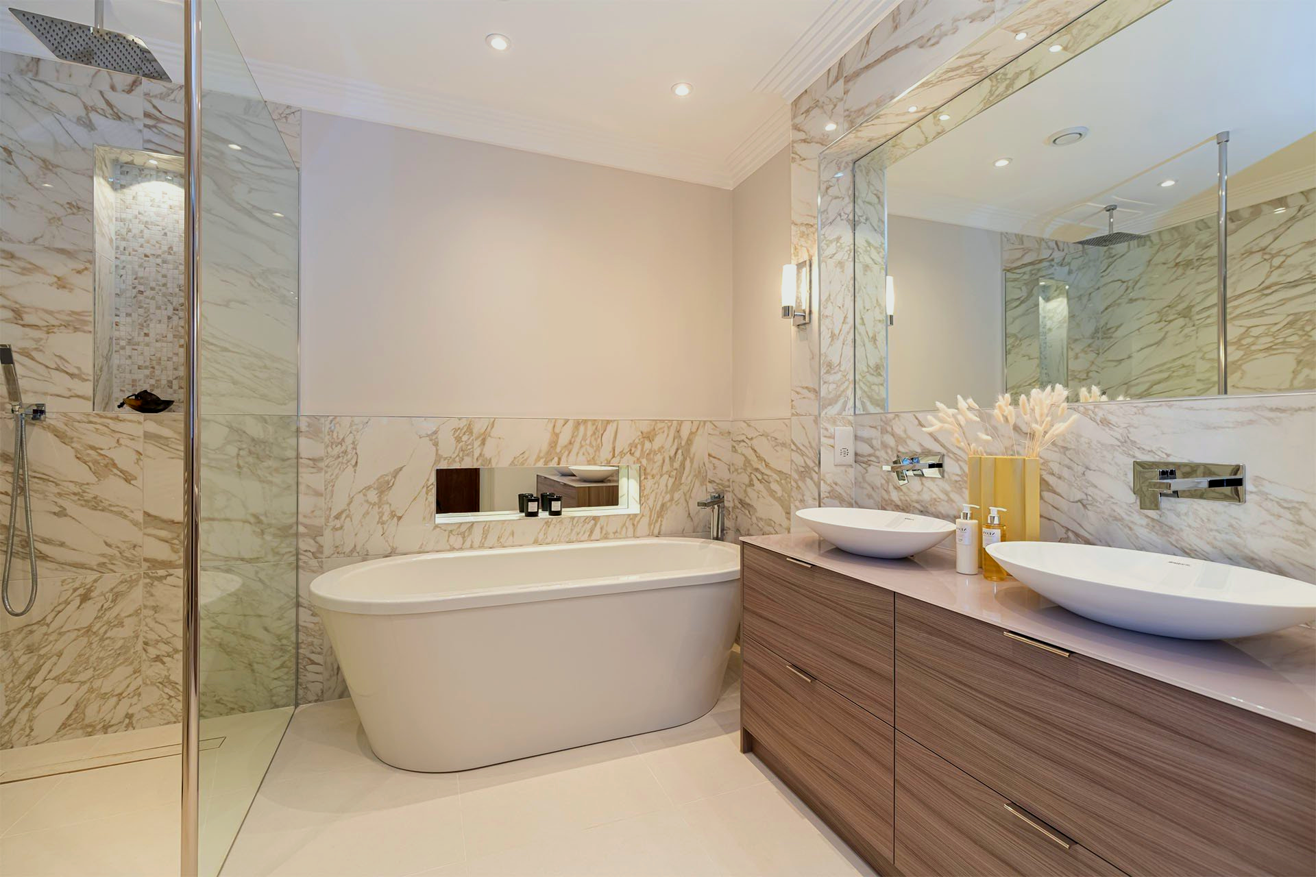 A bathroom with a bathtub, sinks and a walk in shower.