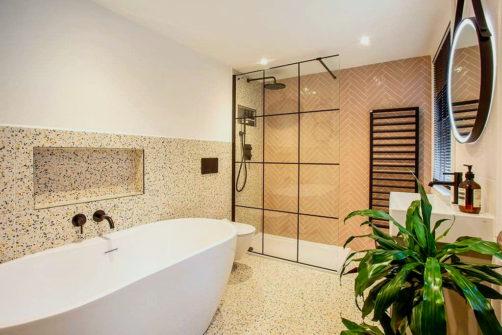 A bathroom with a tub, sink, mirror and shower.