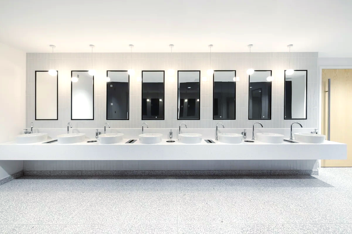 A public restroom with a row of sinks and mirrors.