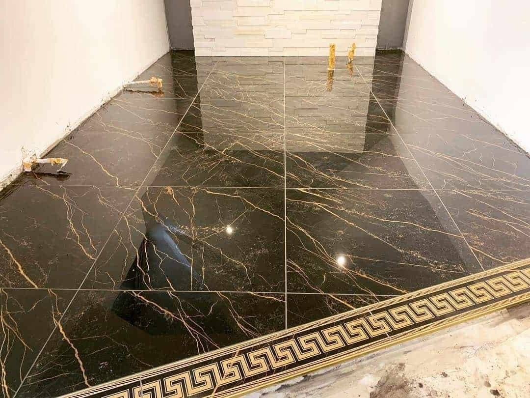 A black and gold tile floor with a greek key pattern.