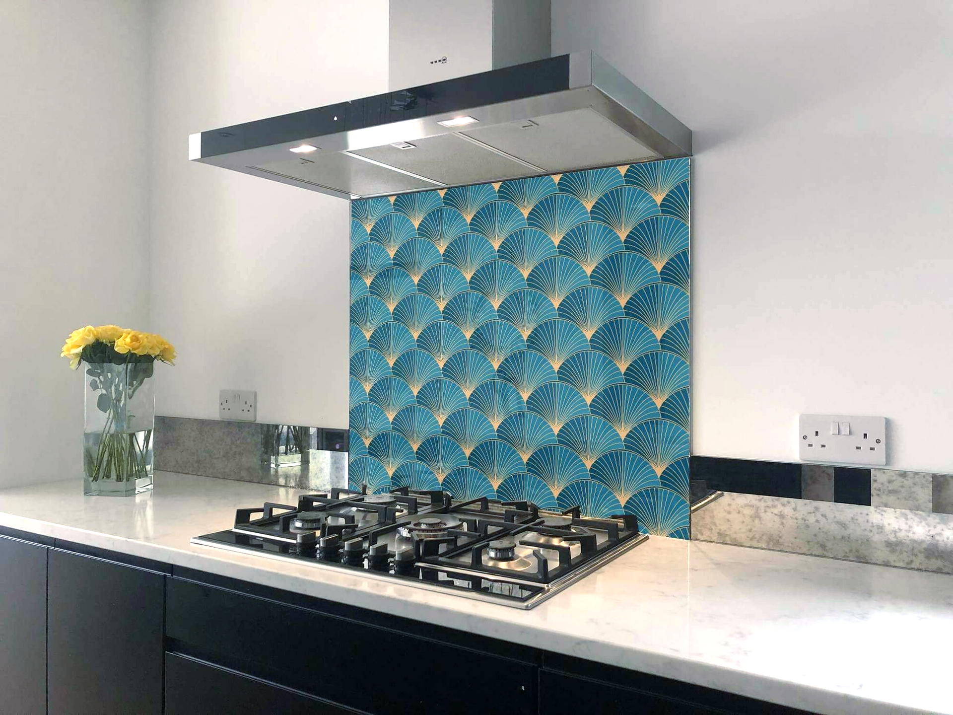 A kitchen with a stove top oven and a hood.
