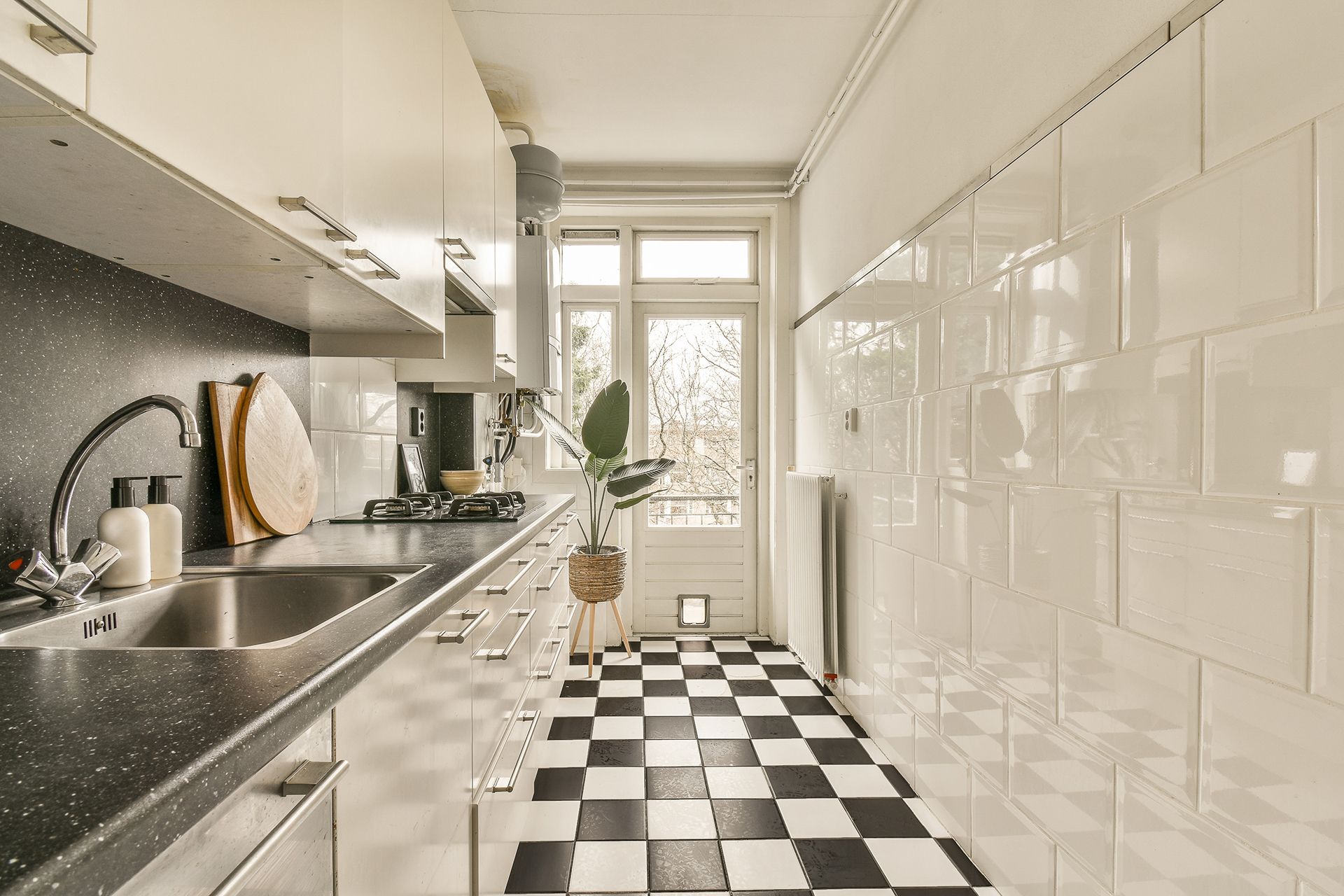 a kitchen with a checkered floor and white cabinets