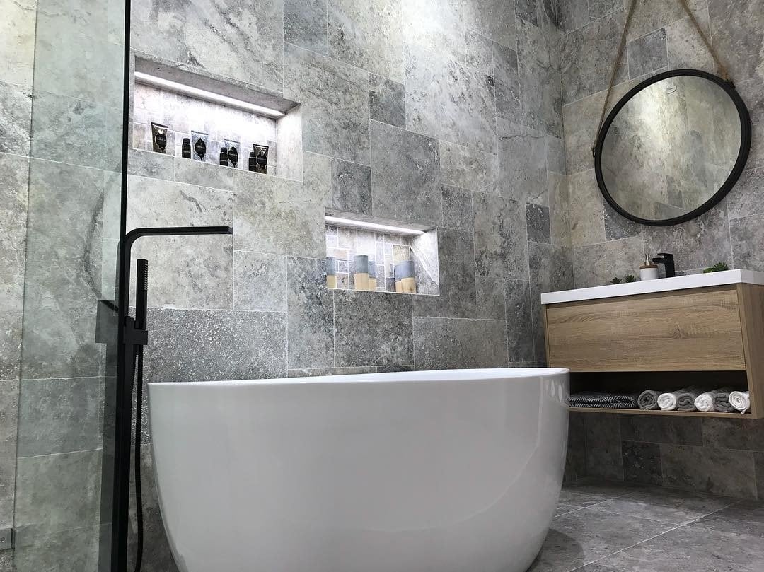 A luxury bathroom with a bathtub, sink, mirror and shower.